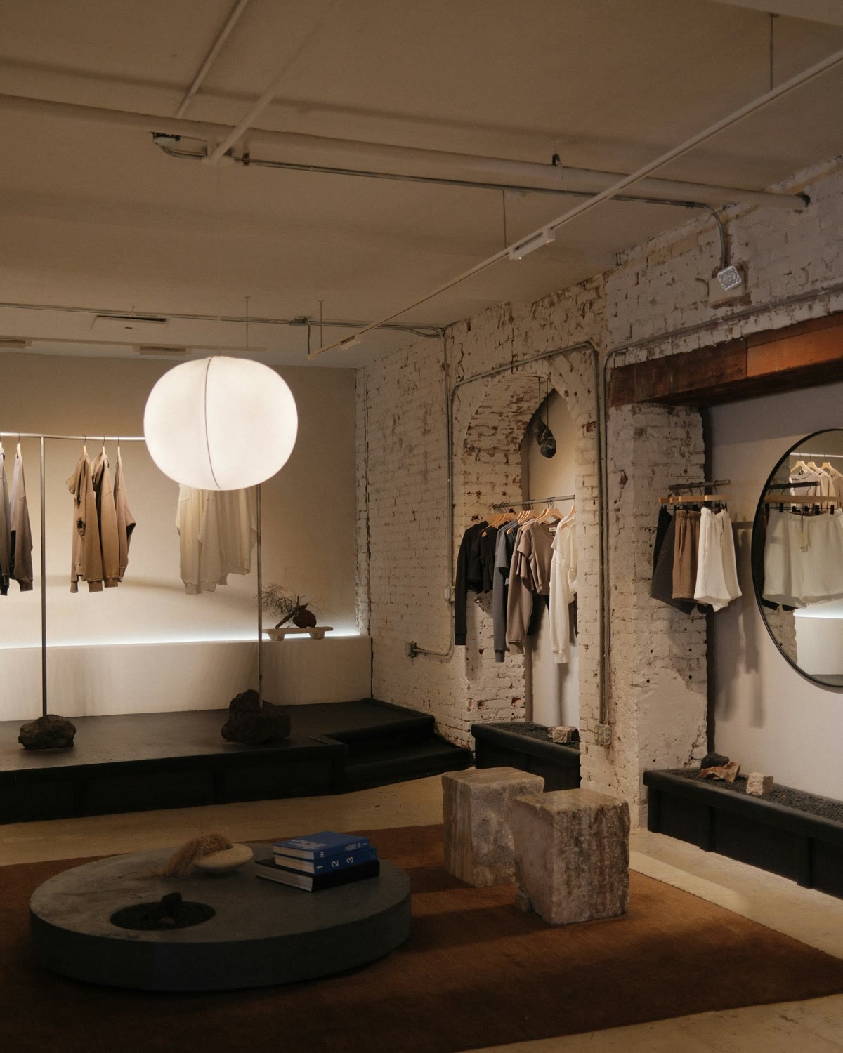 Minimal boutique interior with timber rails, warm spotlighting and quiet product edit